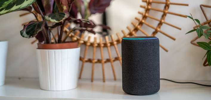 Amazon Alexa Echo Plus on a white table with green plants in the background