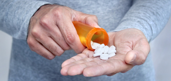 man taking pills pills in his hand