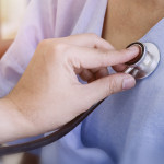 Doctor checking patient's heart with stethoscope at a hospital