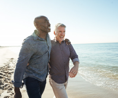 older gay couple walking on the beach
