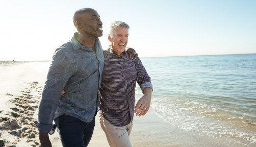 older gay couple walking on the beach
