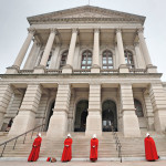 woman dressed in handmaids tale red outfits protest cuts to abortion funding