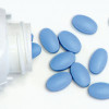 blue pills spill out of white bottle