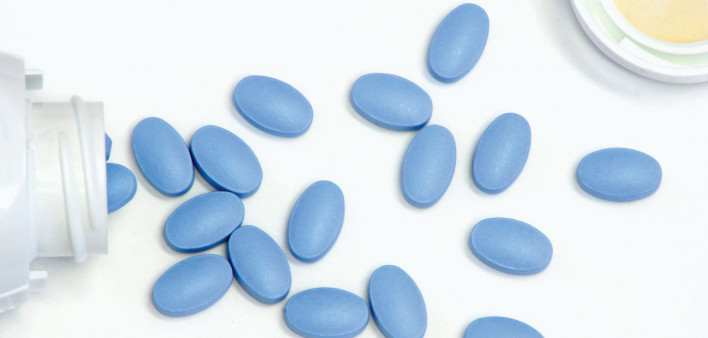 blue pills spill out of white bottle