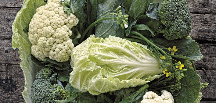 Green leafy vegetables in a wooden tray.