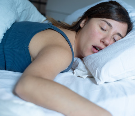 Face close up portrait of woman sleeping in bed and snoring