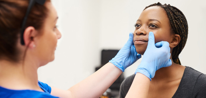 woman gets face examination by doctor botox