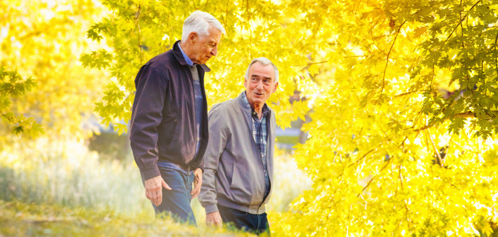Senior gay couple enjoying a walk sunny Autumn day