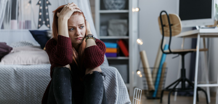 young woman depress holding head in bedroom