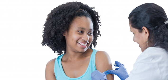 girl receiving vaccine from female doctor