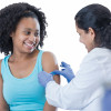 girl receiving vaccine from female doctor