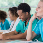 Diverse pre-med students take notes during class