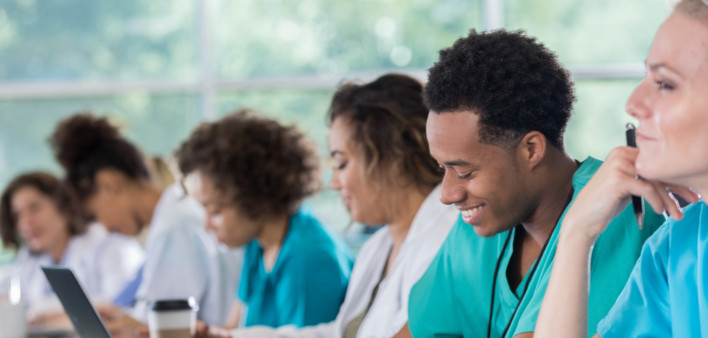 Diverse pre-med students take notes during class