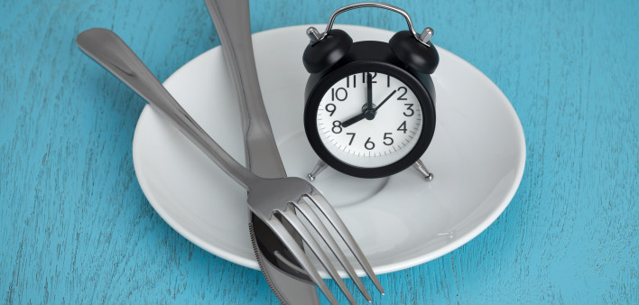 alarm clock on plate with fork and knife fastting diet