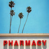Pharmacy sign with sky and palm trees behind