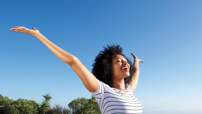 woman outside arms stretched happy