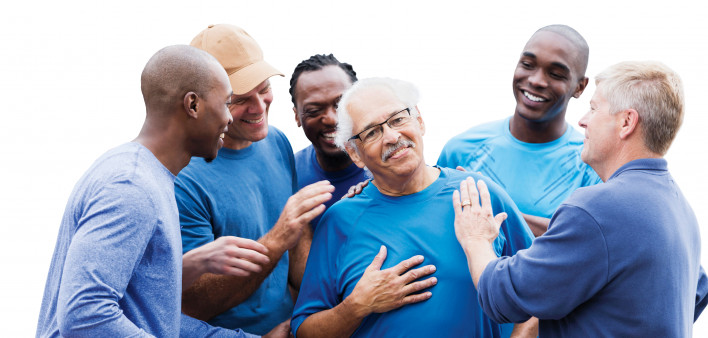 group of men supporting one man smiling