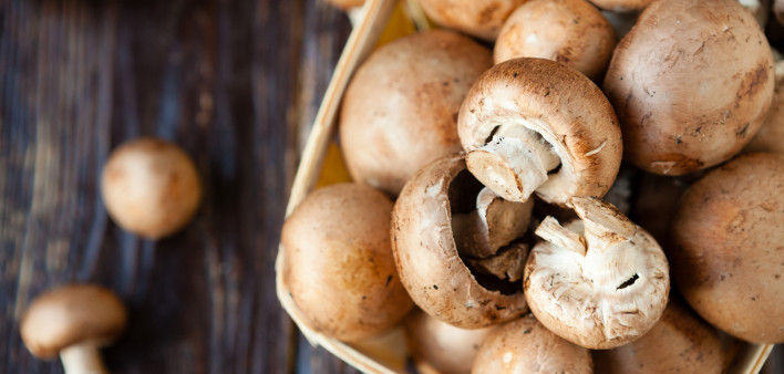 Champignons in a basket on dark boards mushrooms