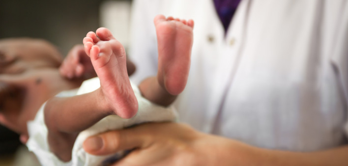 nurse holding baby showing feet