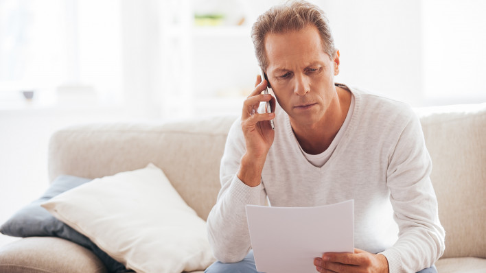 older man on phone discussing document