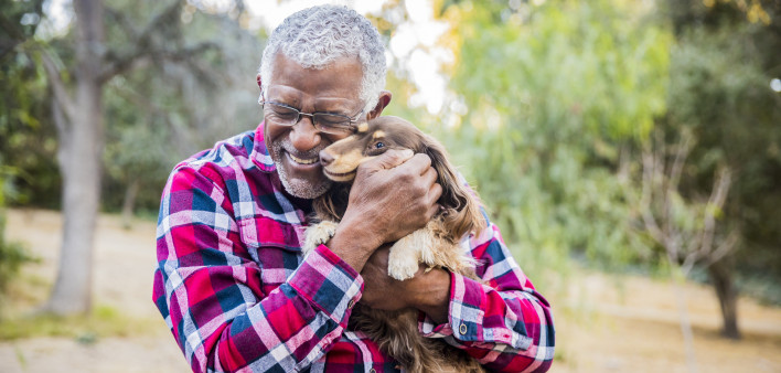 older man holding a dog