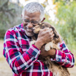 older man holding a dog