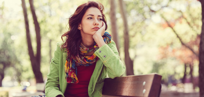 Unhappy girl sitting at bench