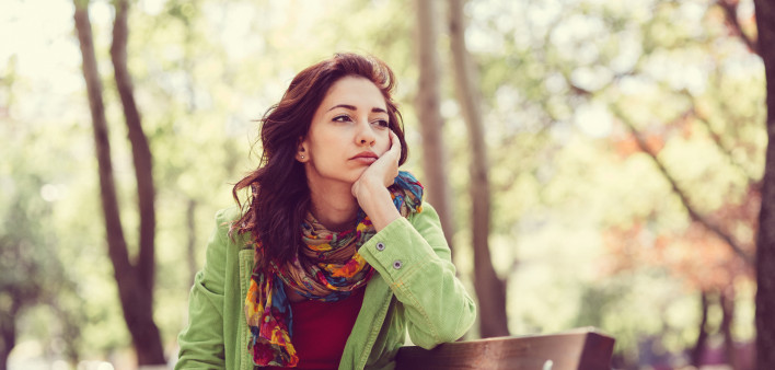 Unhappy girl sitting at bench