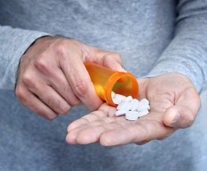 man taking pills pills in his hand