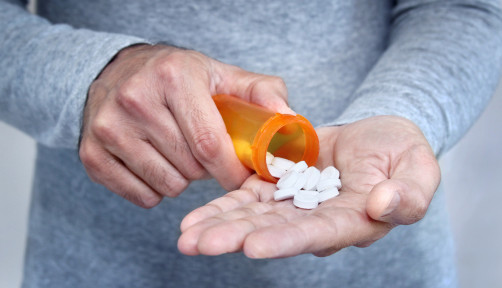 man taking pills pills in his hand