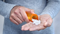 man taking pills pills in his hand