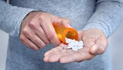 man taking pills pills in his hand