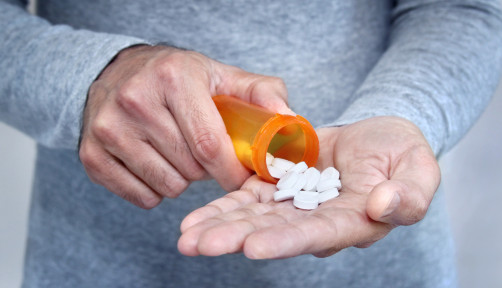 man taking pills pills in his hand