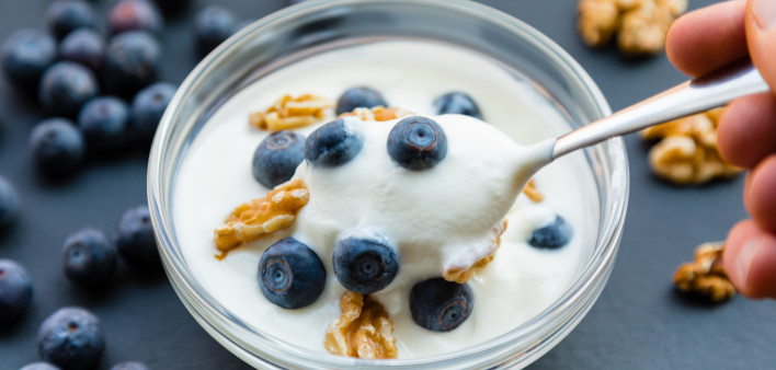 glass bowl yogurt blueberries and walnuts spoon