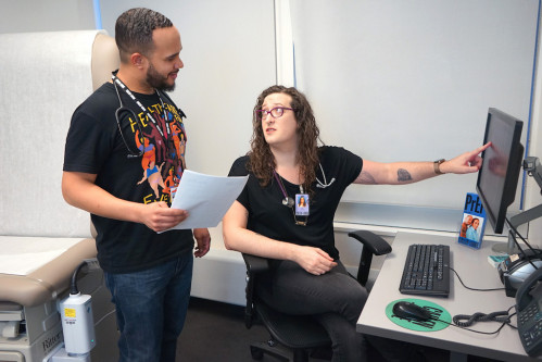 Associate director of transgender medicine, Zil Goldstein, NP, counsels with a nursing coordinator about a patient chart.