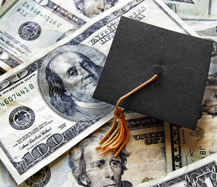 Graduation cap on cash 100 dollar bills