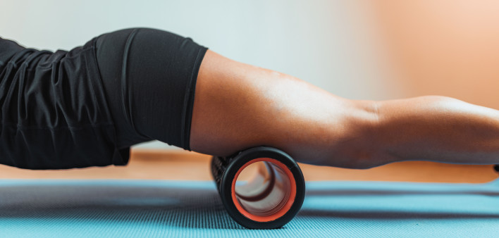 womans legs on roller gym mat