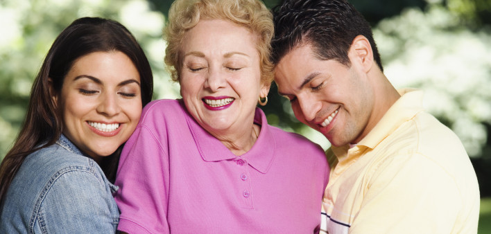 Hispanic mother with adult children hugging