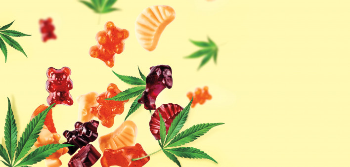 Colored gummies fly along with cannabis leaves. Chewing candies, gummies with CBD oil and THC. Colorful creative background,
