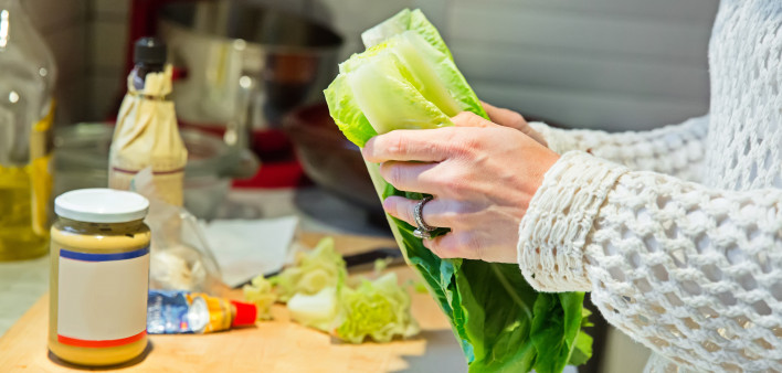 A woman making a Ceaser salad for dinner.