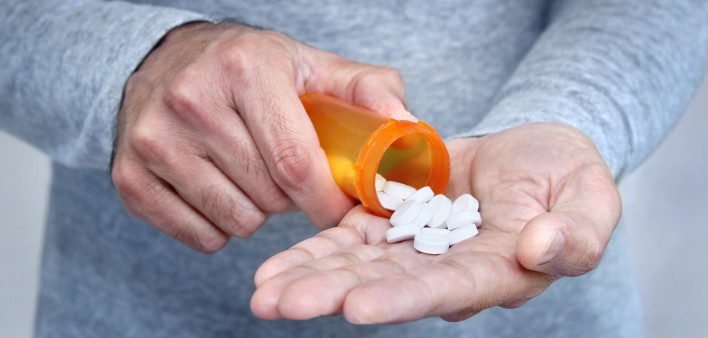 man taking pills pills in his hand
