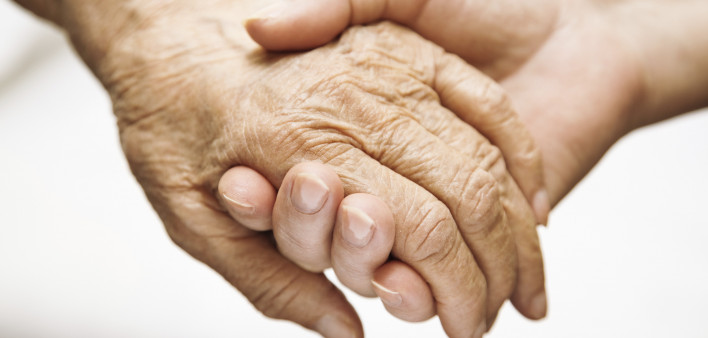 one hand holds the other elderly hand