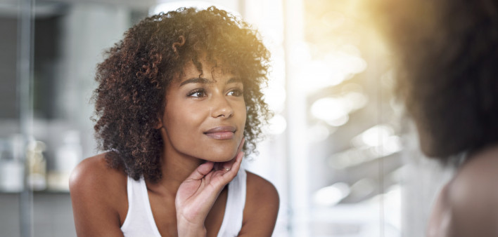 An African American woman looking in a mirror