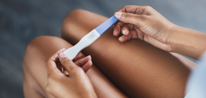 womans hands holding pregnancy test