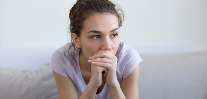 pensive depressed girl sitting on couch