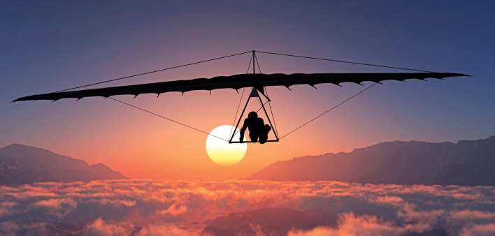 man hang gliding sunset clouds