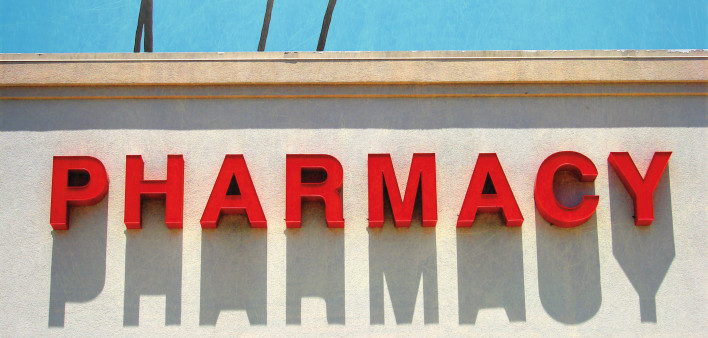 Pharmacy sign with sky and palm trees behind