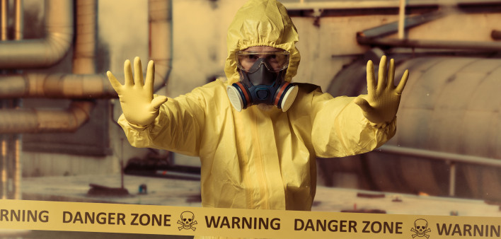 man in protective yellow gear and gas mask danger zone