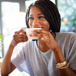 Beautiful young african woman enjoying a cup of coffee in coffee shop