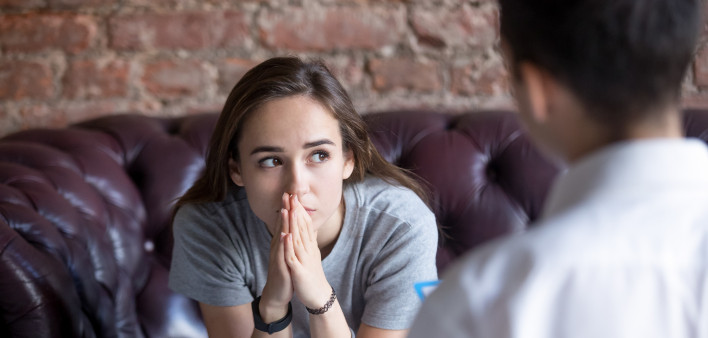 Young woman visiting therapist counselor.